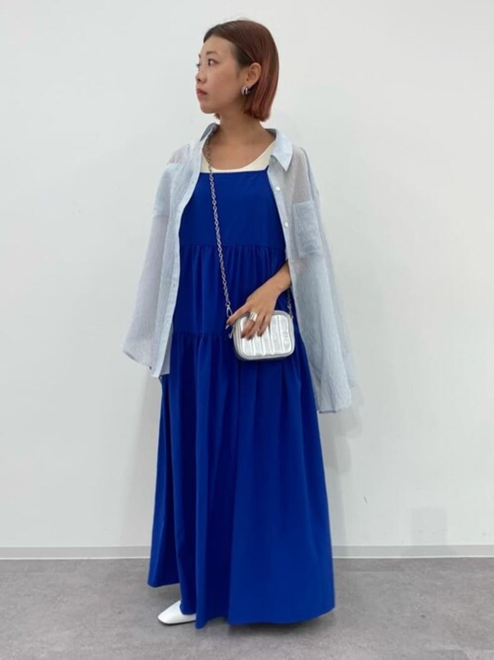 ブルー系のワンピース、ホワイト系のニット/セーター、グレー系のシャツ/ブラウスを着用したレディースの夏コーディネートの1枚目の写真