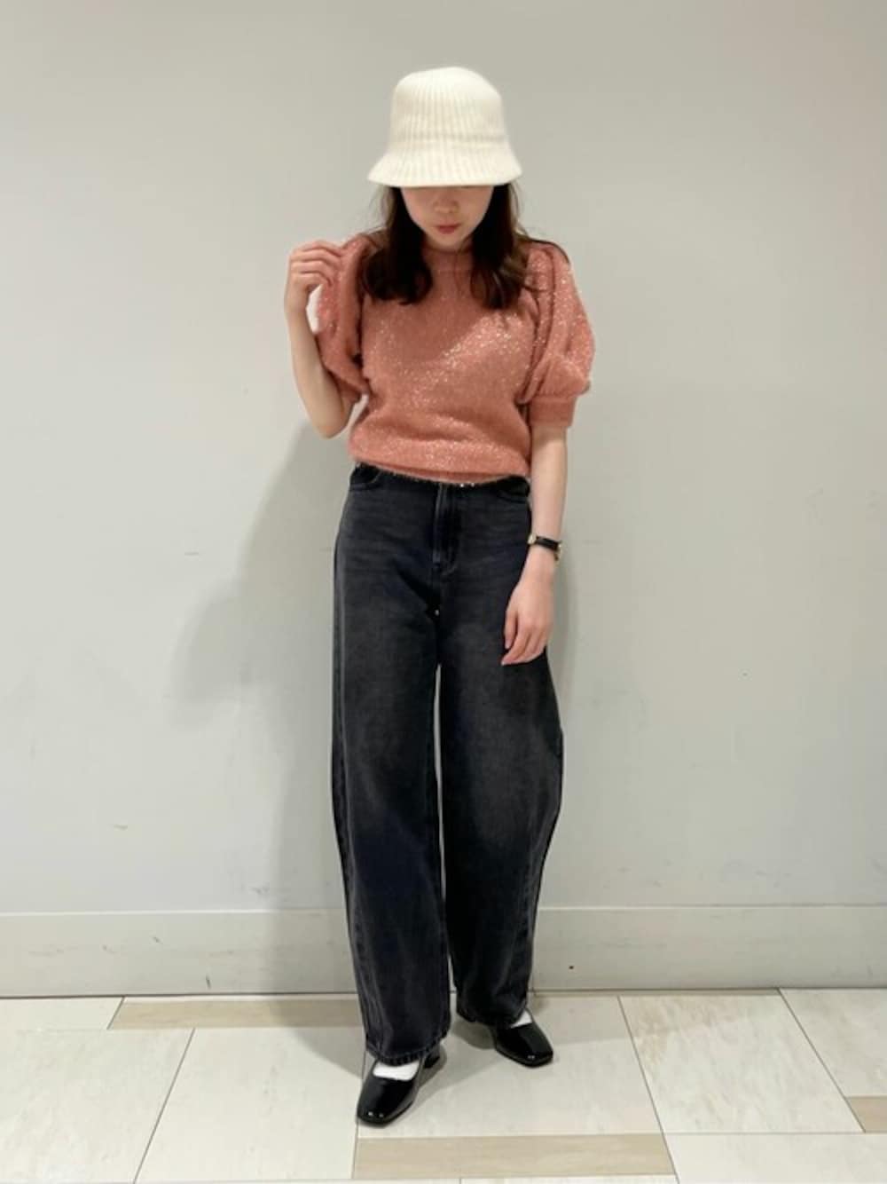 ブラック系のデニムパンツ、ピンク系のニット/セーター、ブラック系のパンプスを着用したレディースの夏コーディネートの1枚目の写真