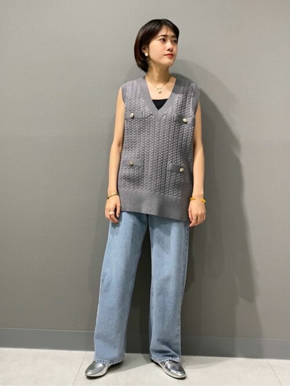 グレー系のニット/セーター、ブルー系のデニムパンツ、ブラック系のタンクトップを着用したレディースの夏コーディネートの1枚目の写真