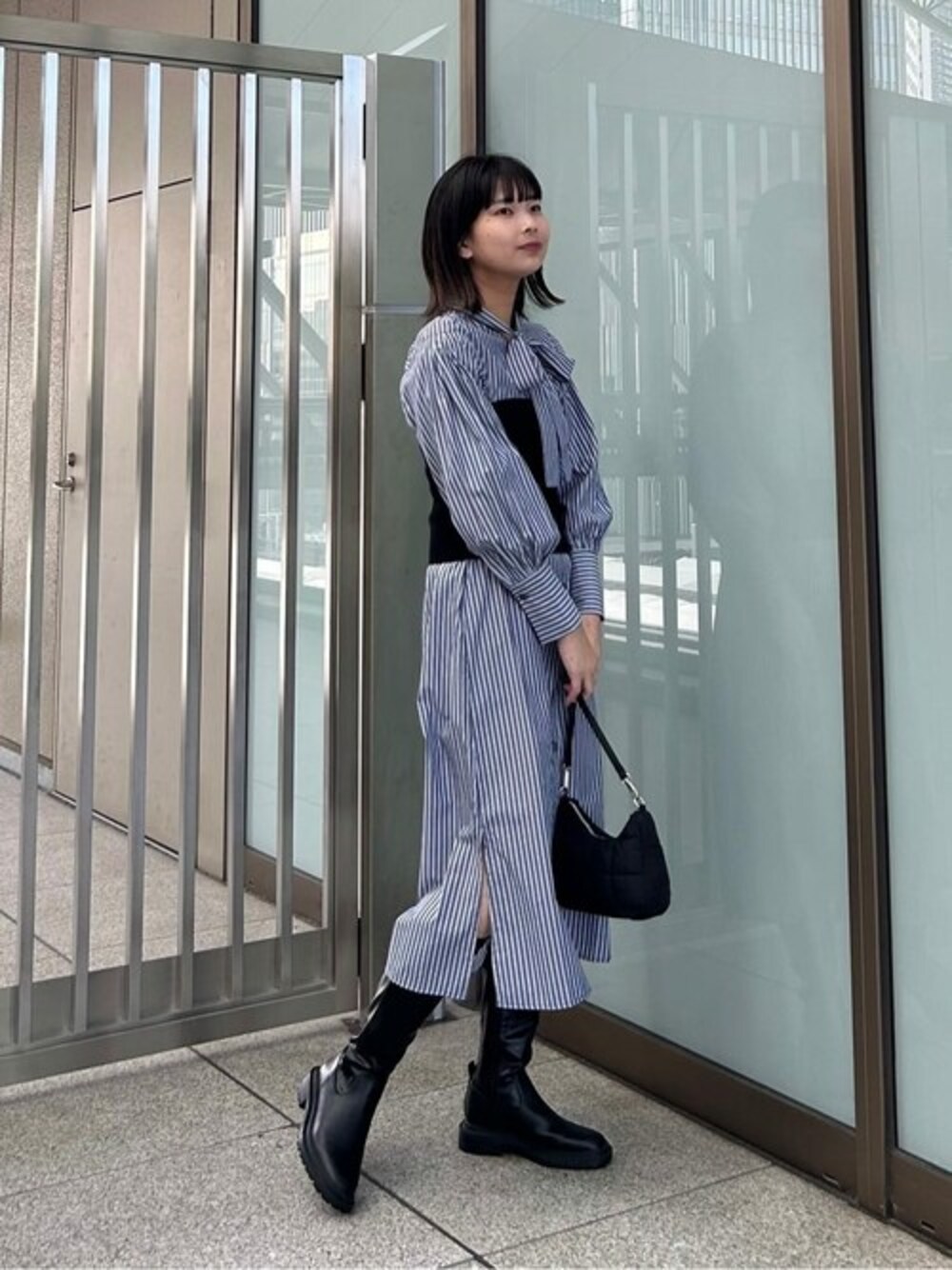 ブルー系のシャツワンピース、ブラック系のチューブトップ、ブラック系のビジネスバッグを着用したレディースの夏コーディネートの1枚目の写真