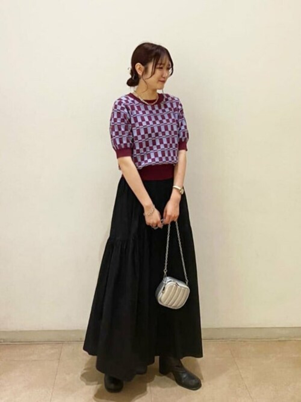 ブラック系のスカート、レッド系のニット/セーター、シルバー系のビジネスバッグを着用したレディースの秋コーディネートの1枚目の写真