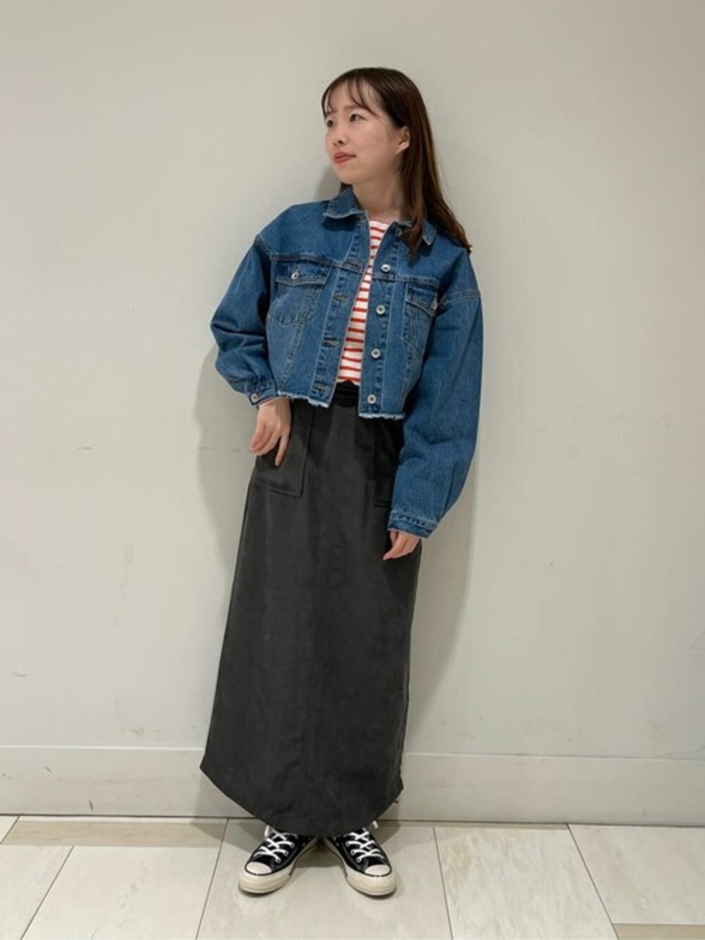 オレンジ系のTシャツ/カットソー、ブルー系のデニムジャケット、グレー系のスカートを着用したレディースの秋コーディネートの1枚目の写真