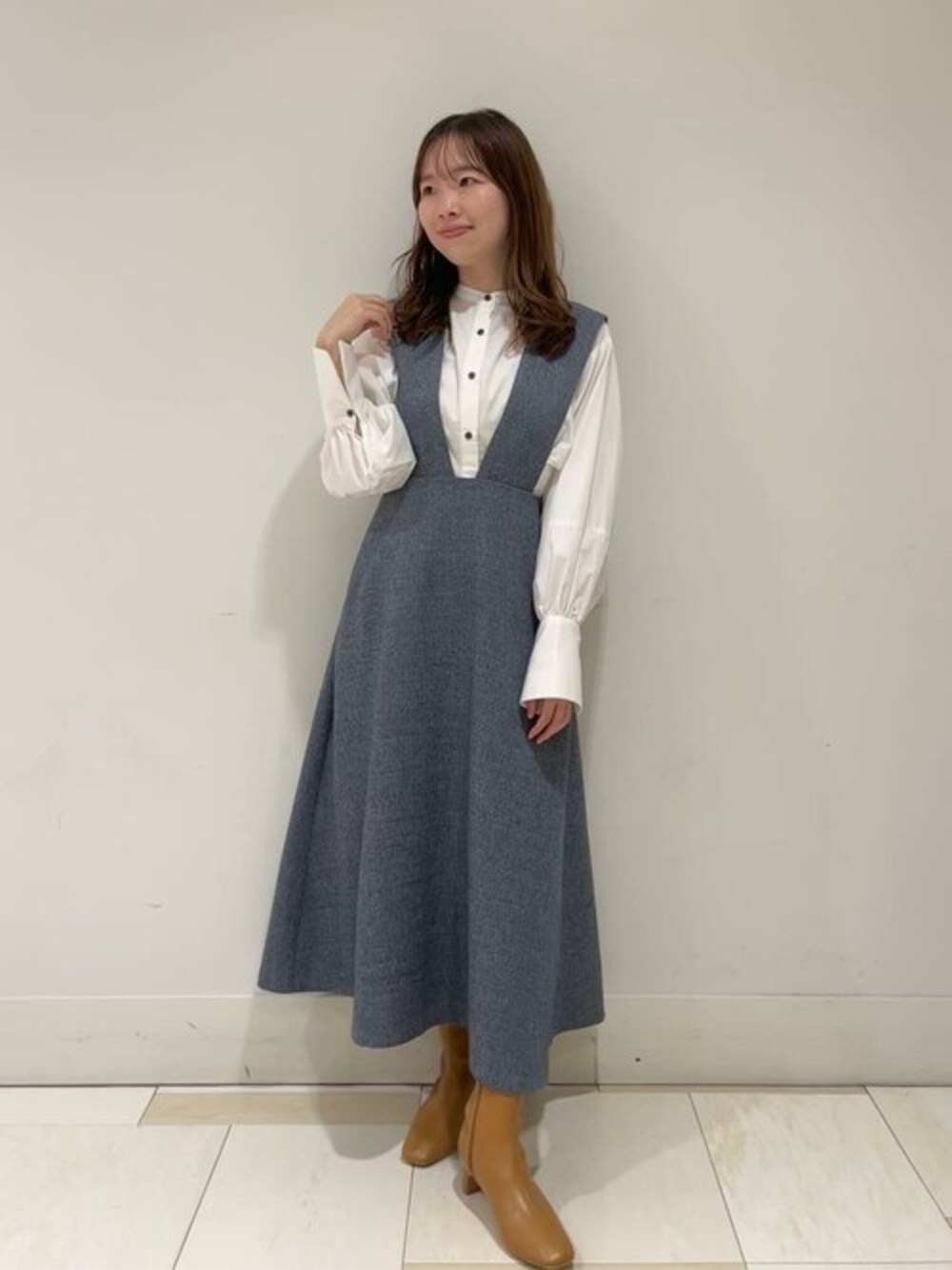 ブルー系のワンピース、ホワイト系のシャツ/ブラウス、ベージュ系のブーツを着用したレディースの秋コーディネートの1枚目の写真