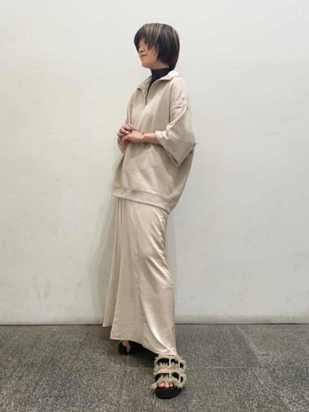 ベージュ系のスウェット、ホワイト系のスカートを着用したレディースの秋コーディネートの1枚目の写真