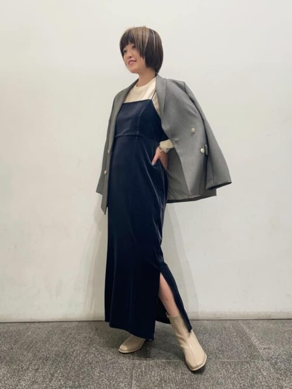 ベージュ系のニット/セーター、グレー系のワンピース、ベージュ系のブーツを着用したレディースの秋コーディネートの1枚目の写真