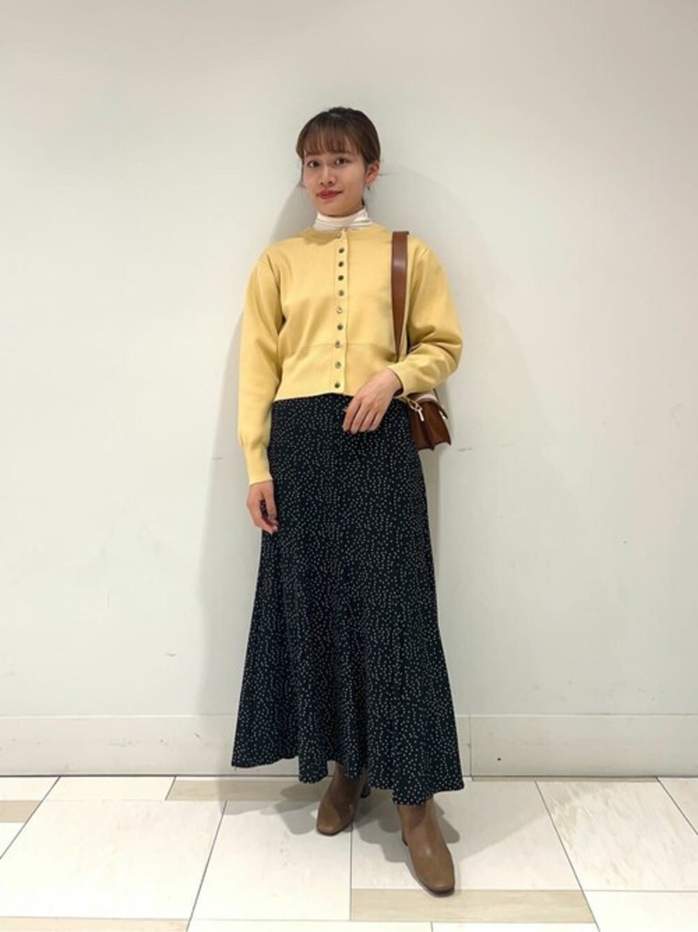 イエロー系のカーディガン/ボレロ、ホワイト系のTシャツ/カットソー、その他のスカートを着用したレディースの秋コーディネートの1枚目の写真