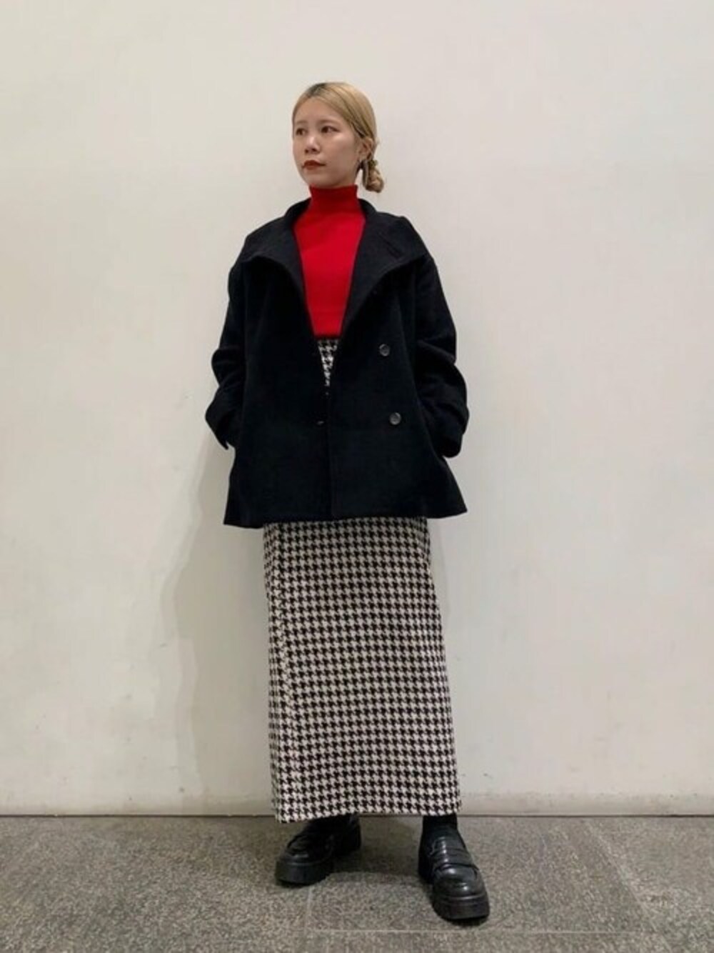 ブラック系のその他アウター、ホワイト系のスカート、レッド系のニット/セーターを着用したレディースの秋コーディネートの1枚目の写真