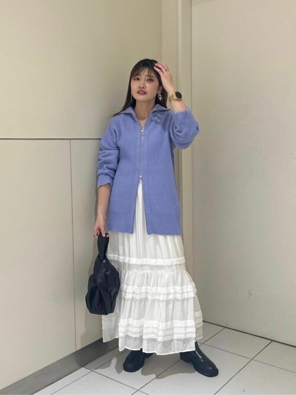 ブルー系のカーディガン/ボレロ、ホワイト系のスカート、ブラック系のブーツを着用したレディースの秋コーディネートの1枚目の写真