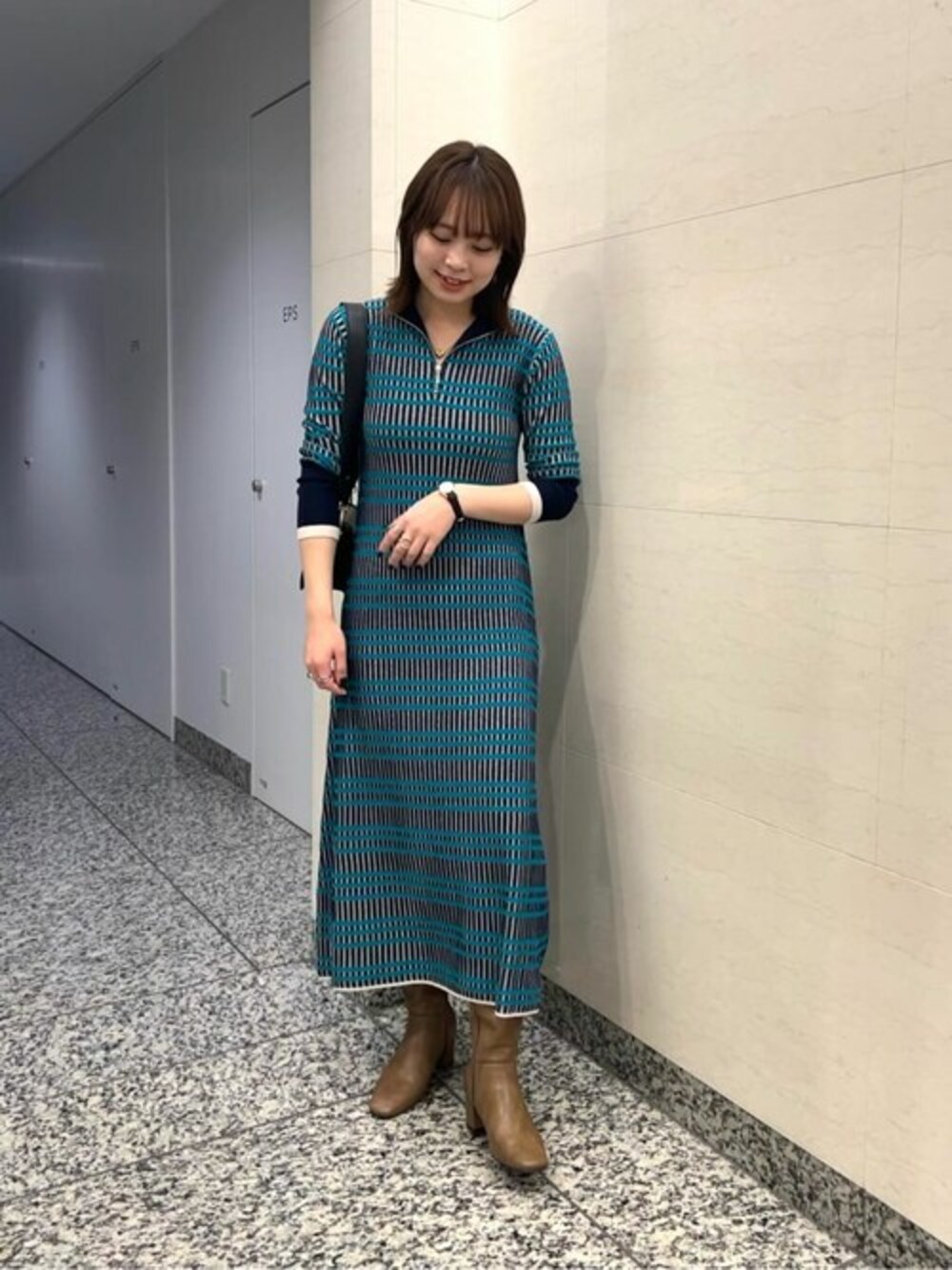 ブルー系のワンピース、ブラック系のビジネスバッグを着用したレディースの秋コーディネートの1枚目の写真