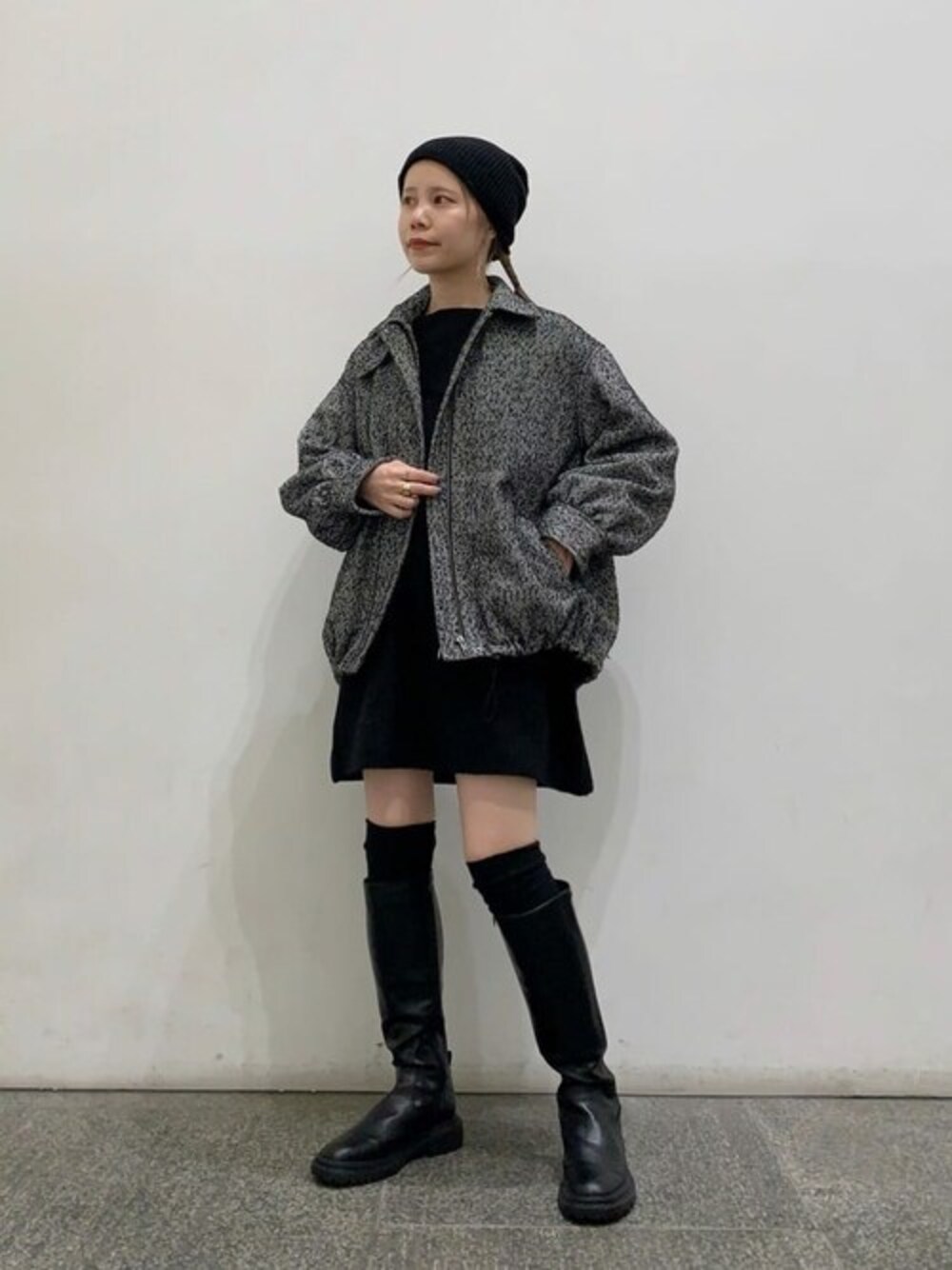 ブラック系のブルゾン、ブラック系のワンピース、ブラック系のブーツを着用したレディースの秋コーディネートの1枚目の写真