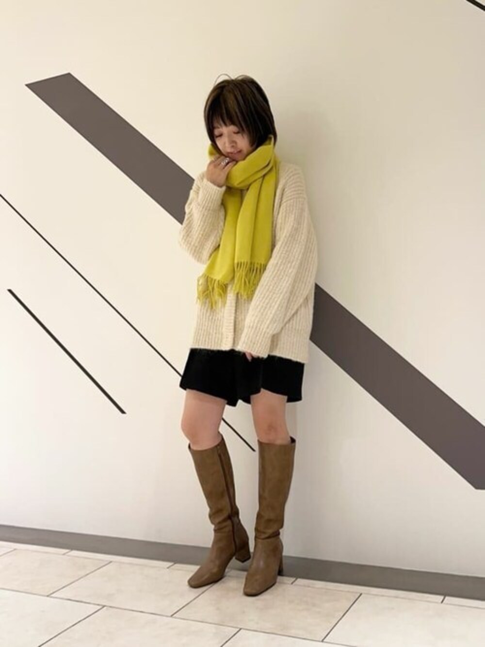 ホワイト系のカーディガン/ボレロ、ブラック系のその他パンツ、イエロー系のストール/ショールを着用したレディースの秋コーディネートの1枚目の写真