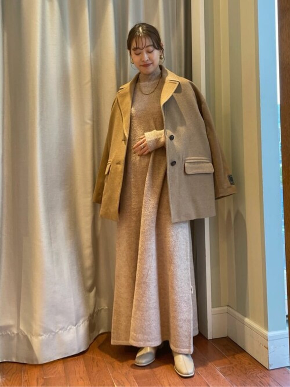 ベージュ系のワンピース、ブラウン系のその他アウター、ベージュ系のブーツを着用したレディースの秋コーディネートの1枚目の写真