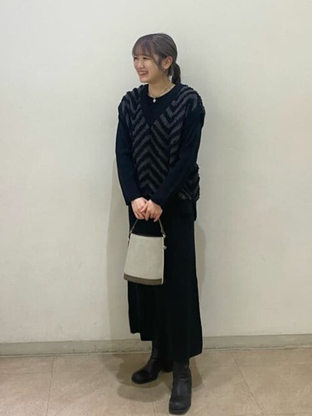 ブラック系のワンピース、グレー系のビジネスバッグを着用したレディースの秋コーディネートの1枚目の写真