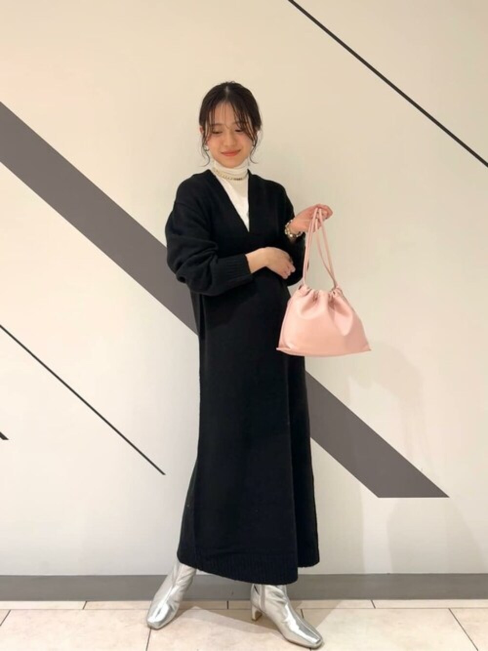 ブラック系のワンピース、ホワイト系のTシャツ/カットソー、シルバー系のブーツを着用したレディースの冬コーディネートの1枚目の写真