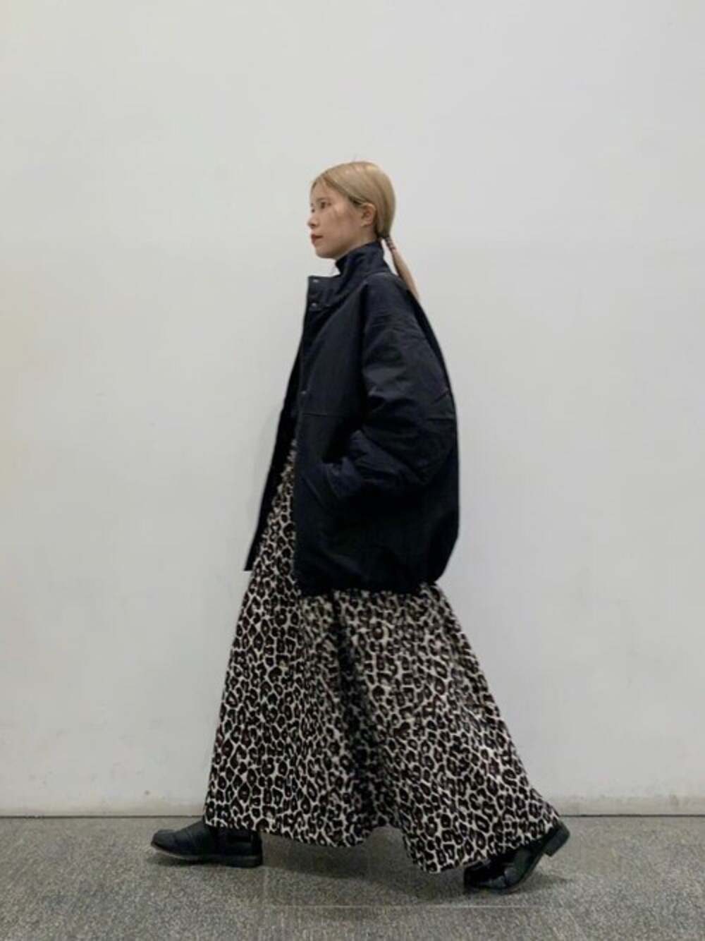 ブラック系のニット/セーター、ホワイト系のスカート、ブラック系のブルゾンを着用したレディースの冬コーディネートの1枚目の写真