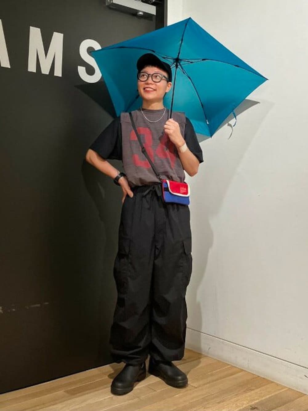 ブルー系の折りたたみ傘を着用したメンズの秋コーディネートの1枚目の写真