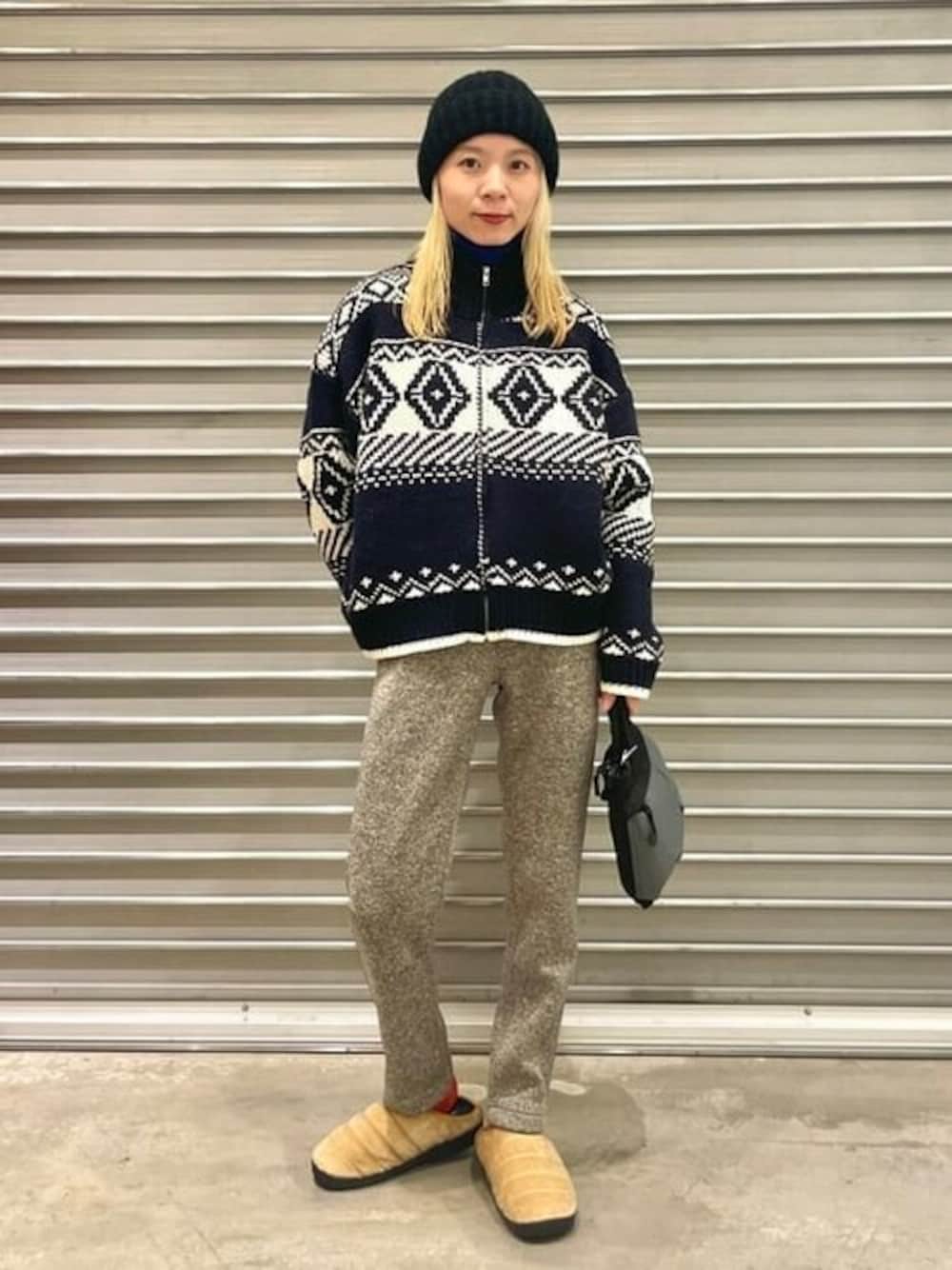 ブラック系のショルダーバッグ、ベージュ系のサンダルを着用したレディースの冬コーディネートの1枚目の写真