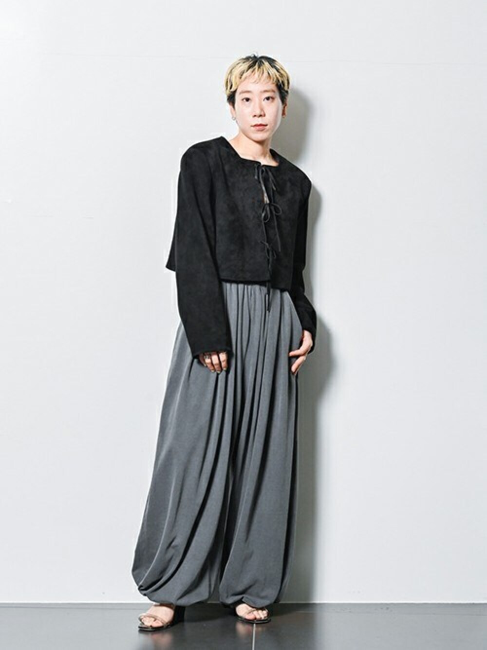 ブラック系のその他アウター、グレー系のスラックスを着用したレディースの夏コーディネートの1枚目の写真