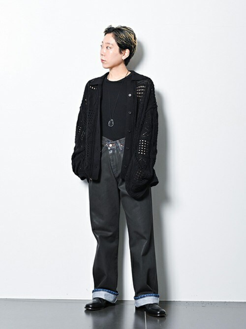 ブラック系のニット/セーター、ブラウン系のデニムパンツ、ホワイト系のネックレスを着用したレディースの秋コーディネートの1枚目の写真