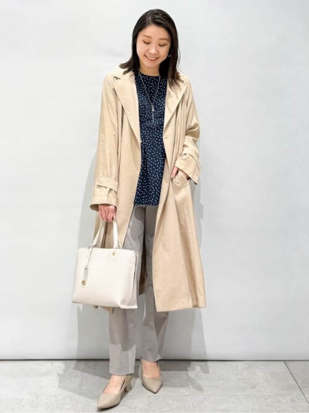 ベージュ系のトレンチコート、ブルー系のシャツ/ブラウス、グレー系のその他パンツを着用したレディースの春コーディネートの1枚目の写真