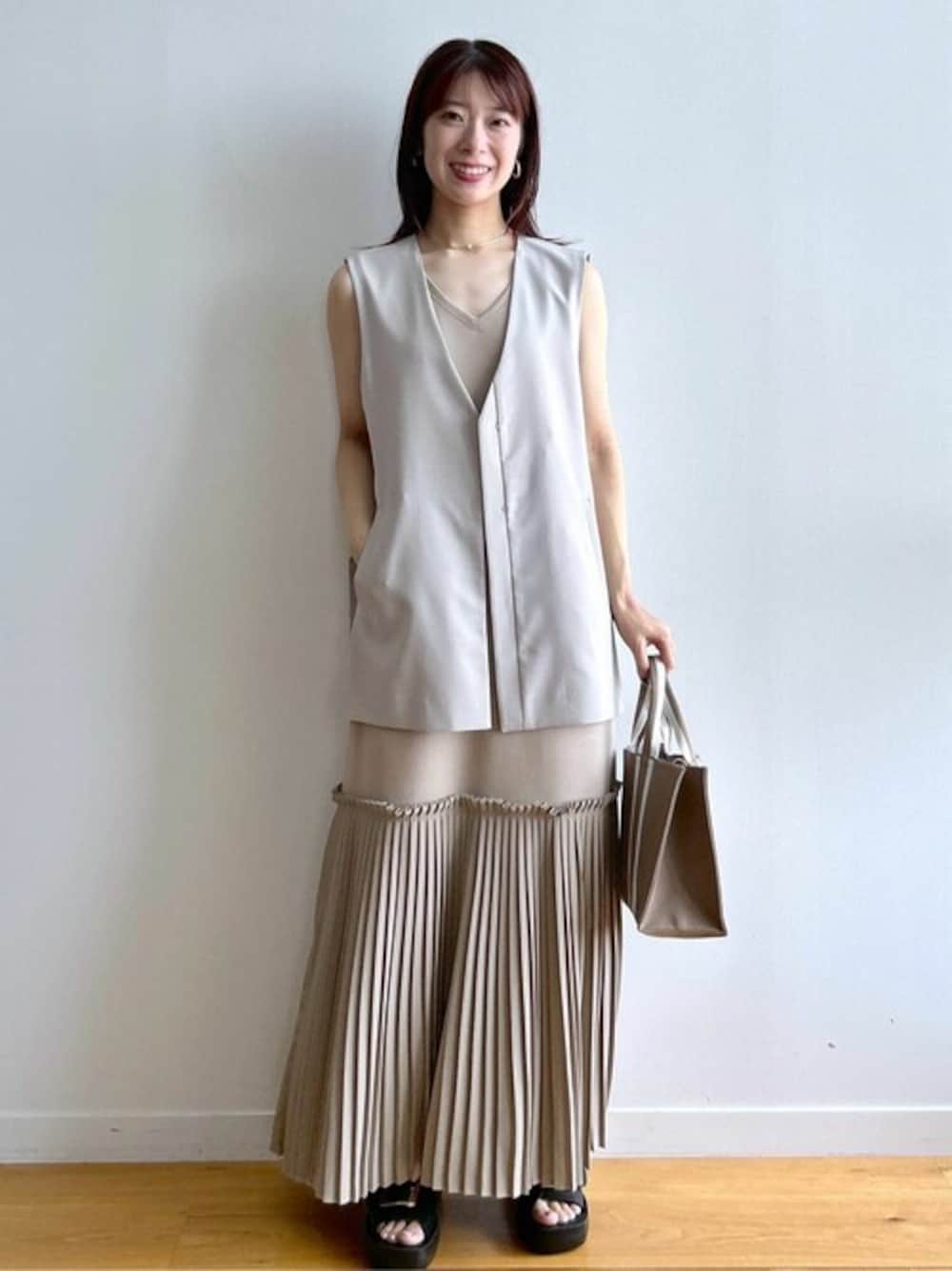 ベージュ系のワンピース、グレー系のベスト、ベージュ系のトートバッグを着用したレディースの夏コーディネートの1枚目の写真