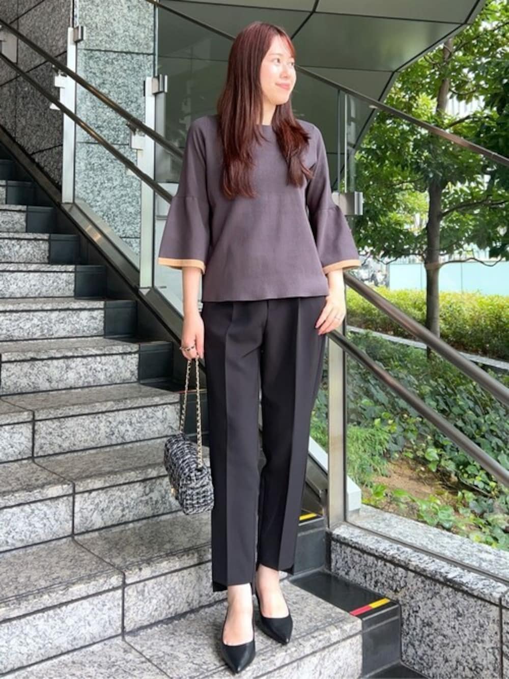 グレー系のニット/セーター、ブラック系のその他パンツ、ブラック系のショルダーバッグを着用したレディースの秋コーディネートの1枚目の写真