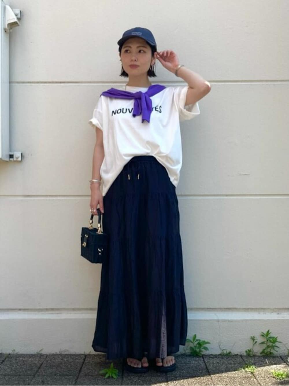 ホワイト系のTシャツ/カットソー、ブラック系のスカート、ブラック系のかごバッグを着用したレディースの夏コーディネートの1枚目の写真