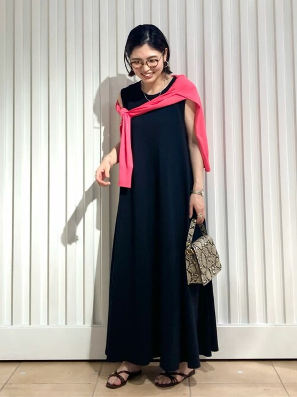 ブラック系のワンピースを着用したレディースの夏コーディネートの1枚目の写真