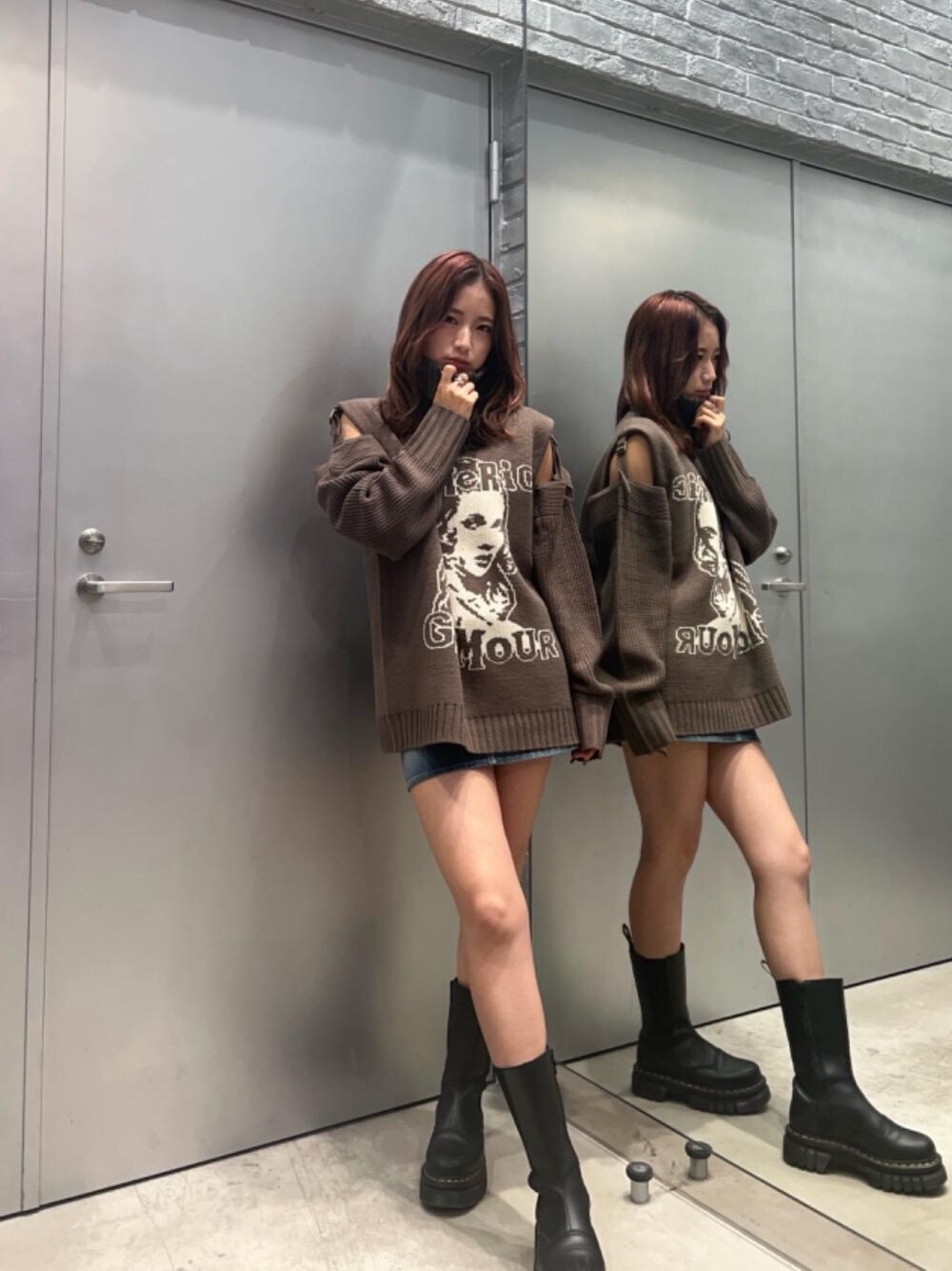 ブルー系のデニムスカート、グレー系のニット/セーターを着用したレディースの秋コーディネートの1枚目の写真