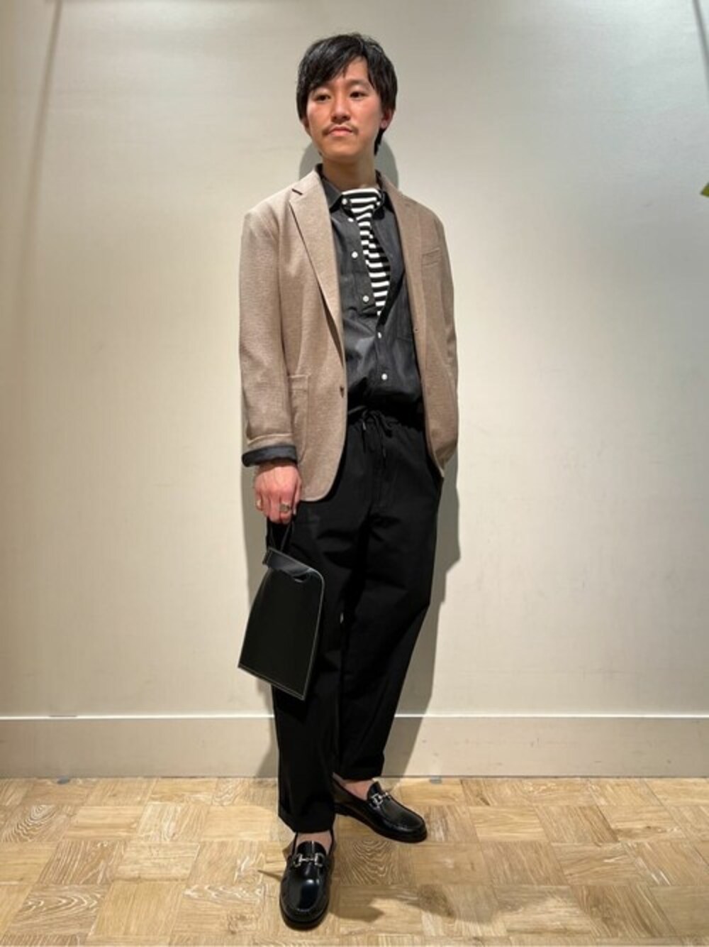 ベージュ系のテーラードジャケット、ブラック系のシャツ/ブラウス、ブラック系のTシャツ/カットソーを着用したメンズの春コーディネートの1枚目の写真