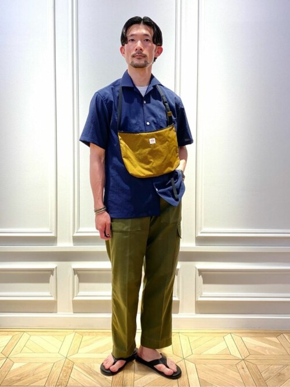 ブルー系のシャツ/ブラウス、イエロー系のショルダーバッグ、ブラック系のサンダルを着用したメンズの夏コーディネートの1枚目の写真