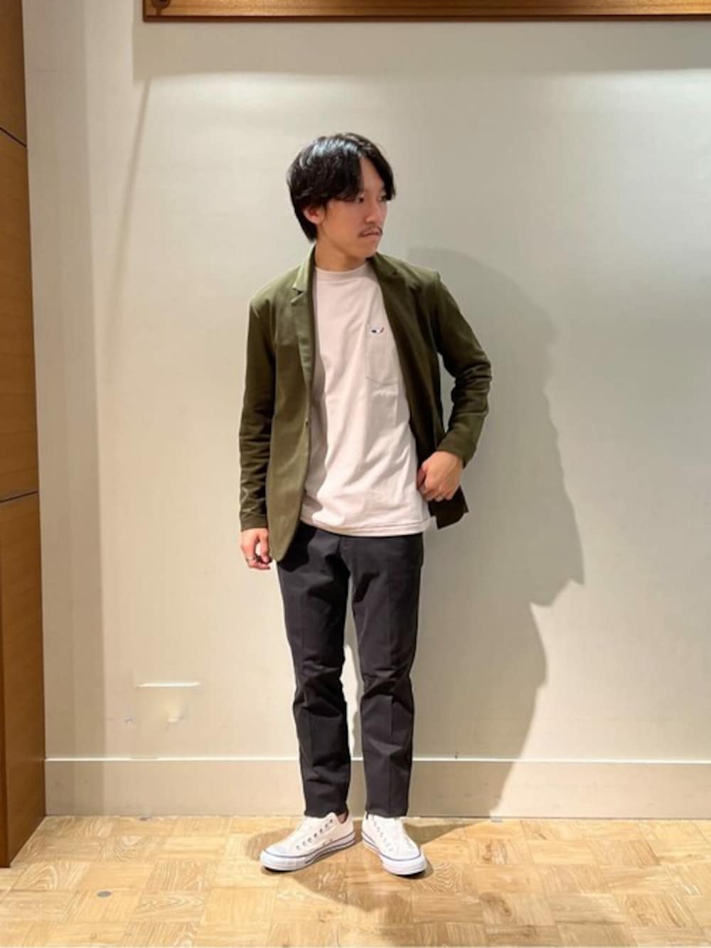 グリーン系のテーラードジャケット、ベージュ系のTシャツ/カットソー、ブラック系のチノパンツを着用したメンズの秋コーディネートの1枚目の写真