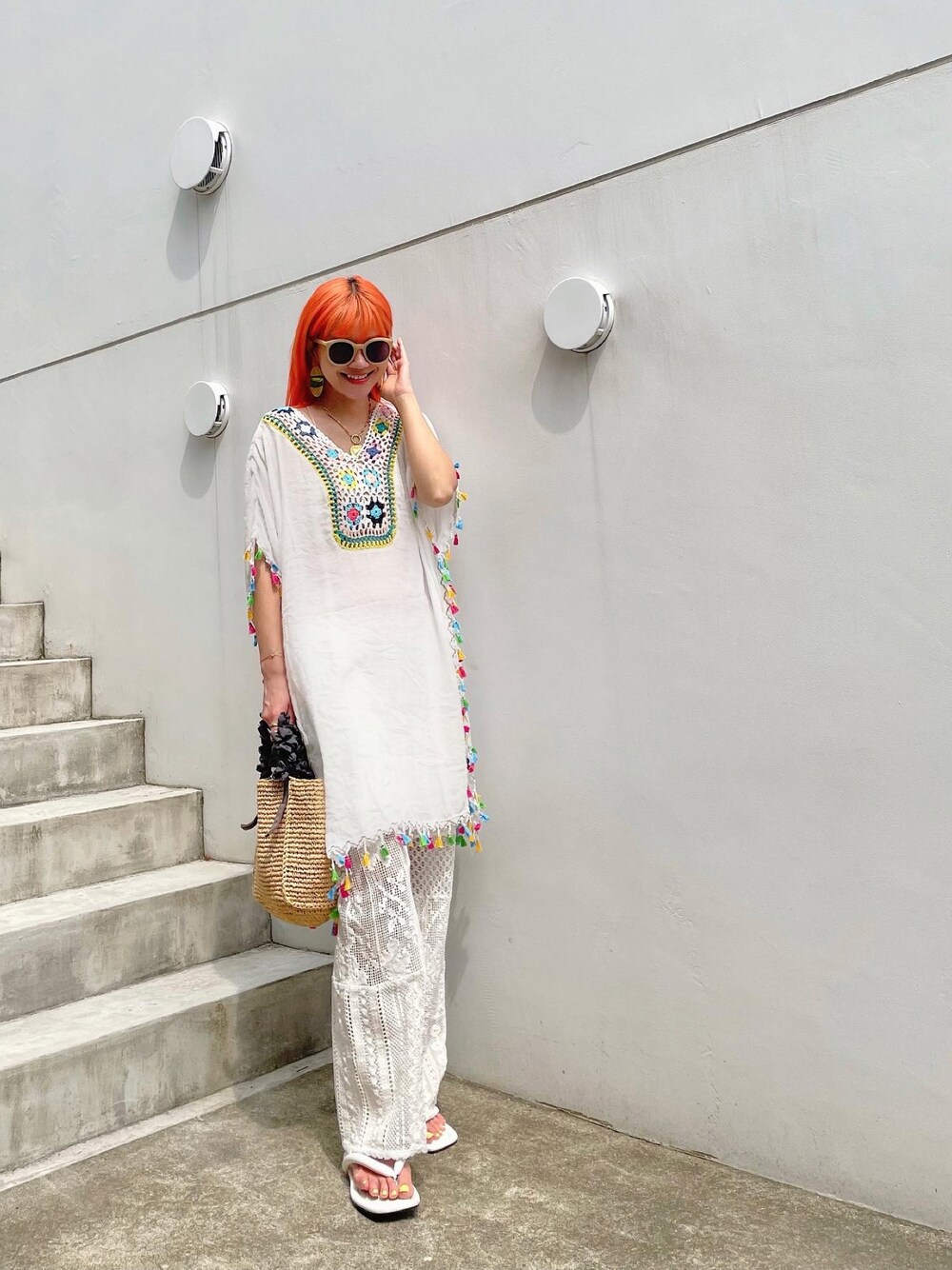 グレー系のトートバッグ、ホワイト系のトップス、ホワイト系のパンツを着用したレディースの春コーディネートの1枚目の写真