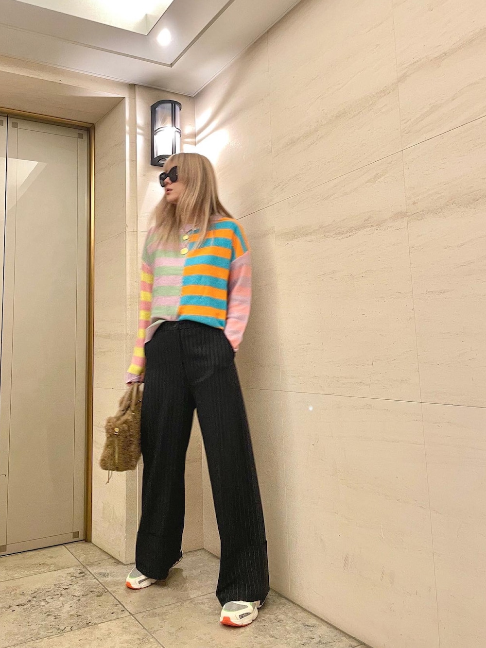 ブルー系のパンツ、その他のスニーカー、ブラウン系のハンドバッグを着用したレディースの秋コーディネートの1枚目の写真