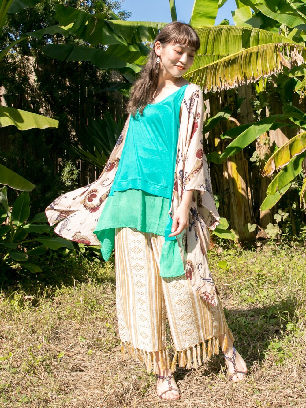 ベージュ系のカーディガン/ボレロ、イエロー系のその他パンツ、ブラウン系のサンダルを着用したレディースの春コーディネートの1枚目の写真