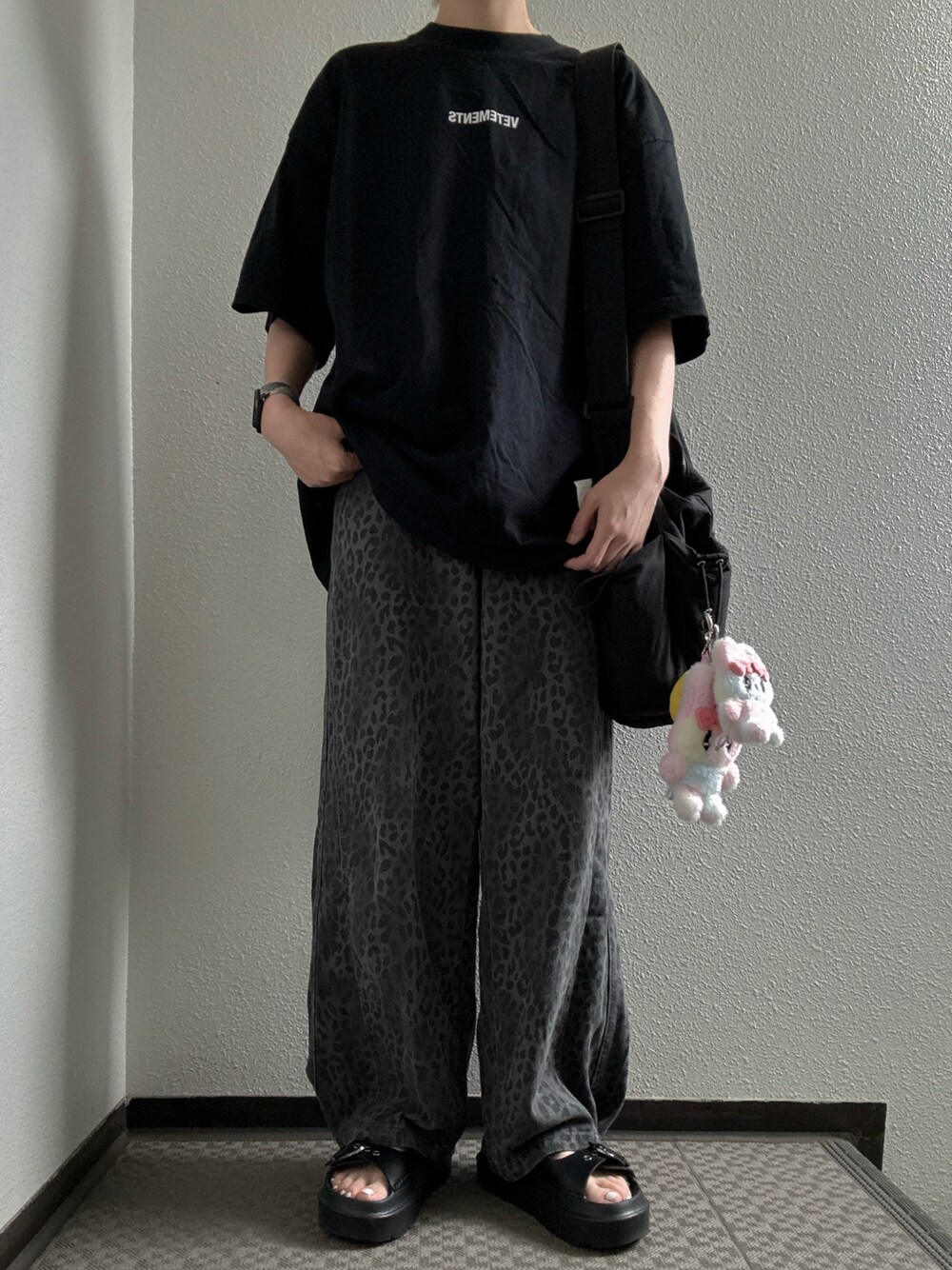 ブラック系のTシャツ/カットソー、ブラック系のショルダーバッグ、グレー系のデニムパンツを着用したレディースの秋コーディネートの1枚目の写真