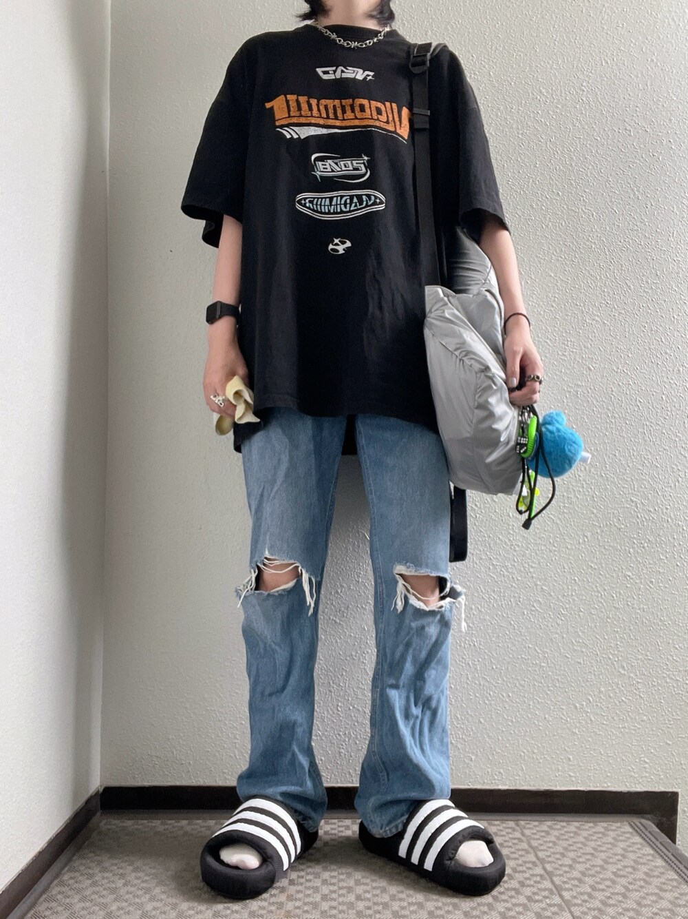 ブラック系のTシャツ/カットソー、シルバー系のバックパック/リュック、ブルー系のデニムパンツを着用したレディースの夏コーディネートの1枚目の写真