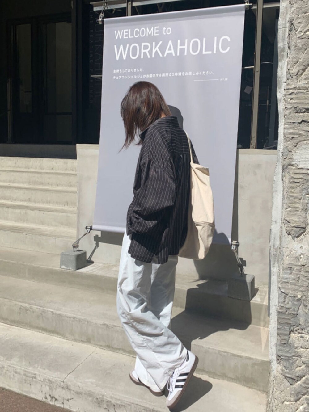 グレー系のシャツ/ブラウス、ホワイト系のニット/セーター、ホワイト系のスラックスを着用したレディースの春コーディネートの1枚目の写真