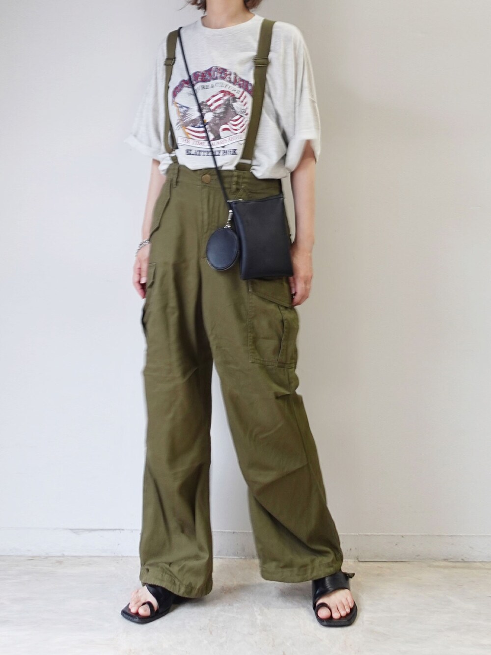 グリーン系のカーゴパンツ、ベージュ系のTシャツ/カットソー、ブラック系のショルダーバッグを着用したレディースの夏コーディネートの1枚目の写真