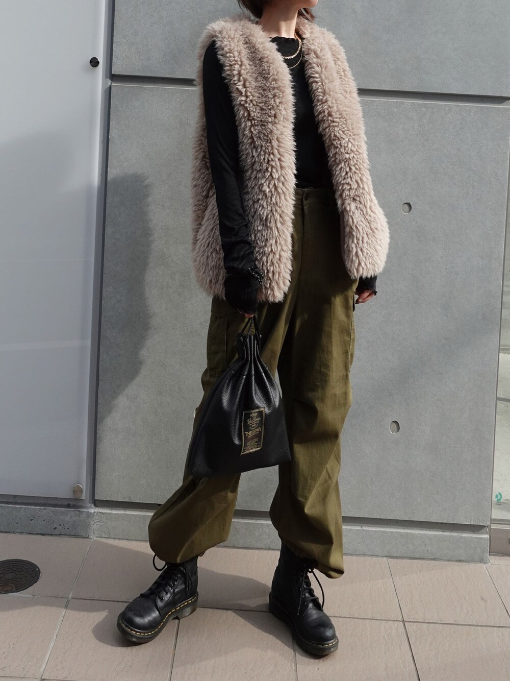 ブラック系のショルダーバッグ、ベージュ系のその他アウター、ブラック系のTシャツ/カットソーを着用したレディースの秋コーディネートの1枚目の写真