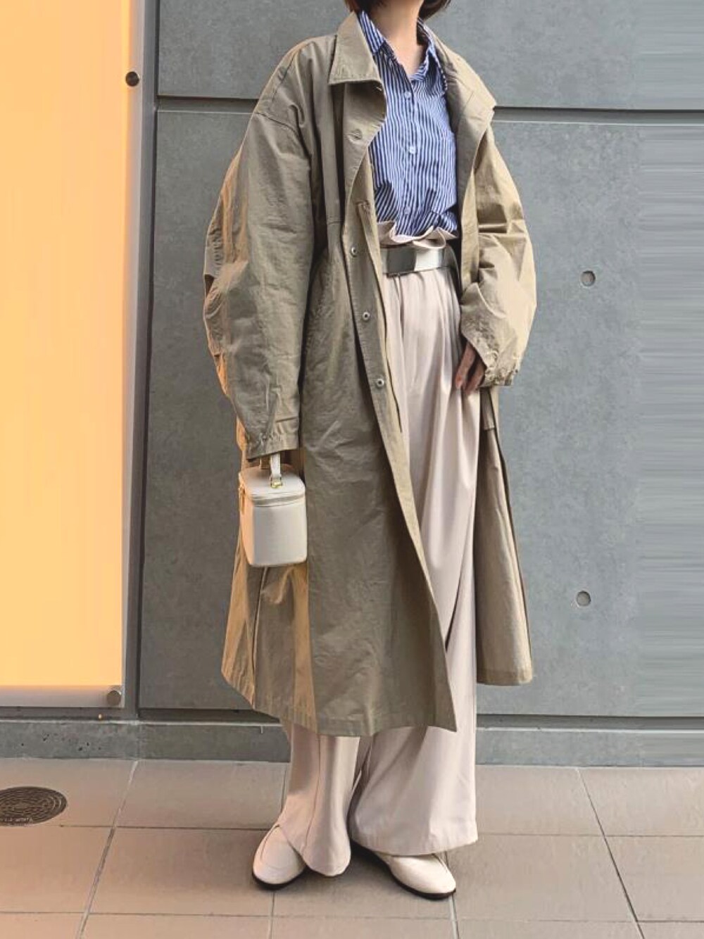 ブルー系のシャツ/ブラウス、ベージュ系のミリタリージャケット、ホワイト系のショルダーバッグを着用したレディースの春コーディネートの1枚目の写真