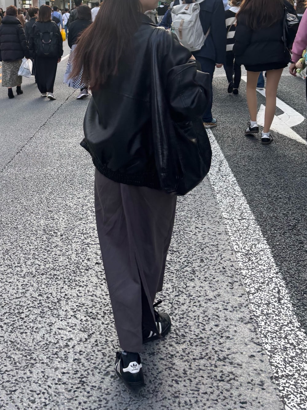 ブラック系のブルゾン、ホワイト系のTシャツ/カットソー、グレー系のジャンパースカートを着用したレディースの秋コーディネートの1枚目の写真