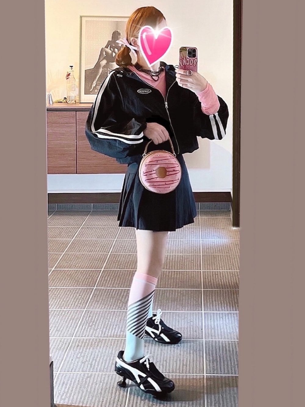 ピンク系のバッグ、ブラック系のスニーカー、ブラック系のスカートを着用したレディースの春コーディネートの1枚目の写真