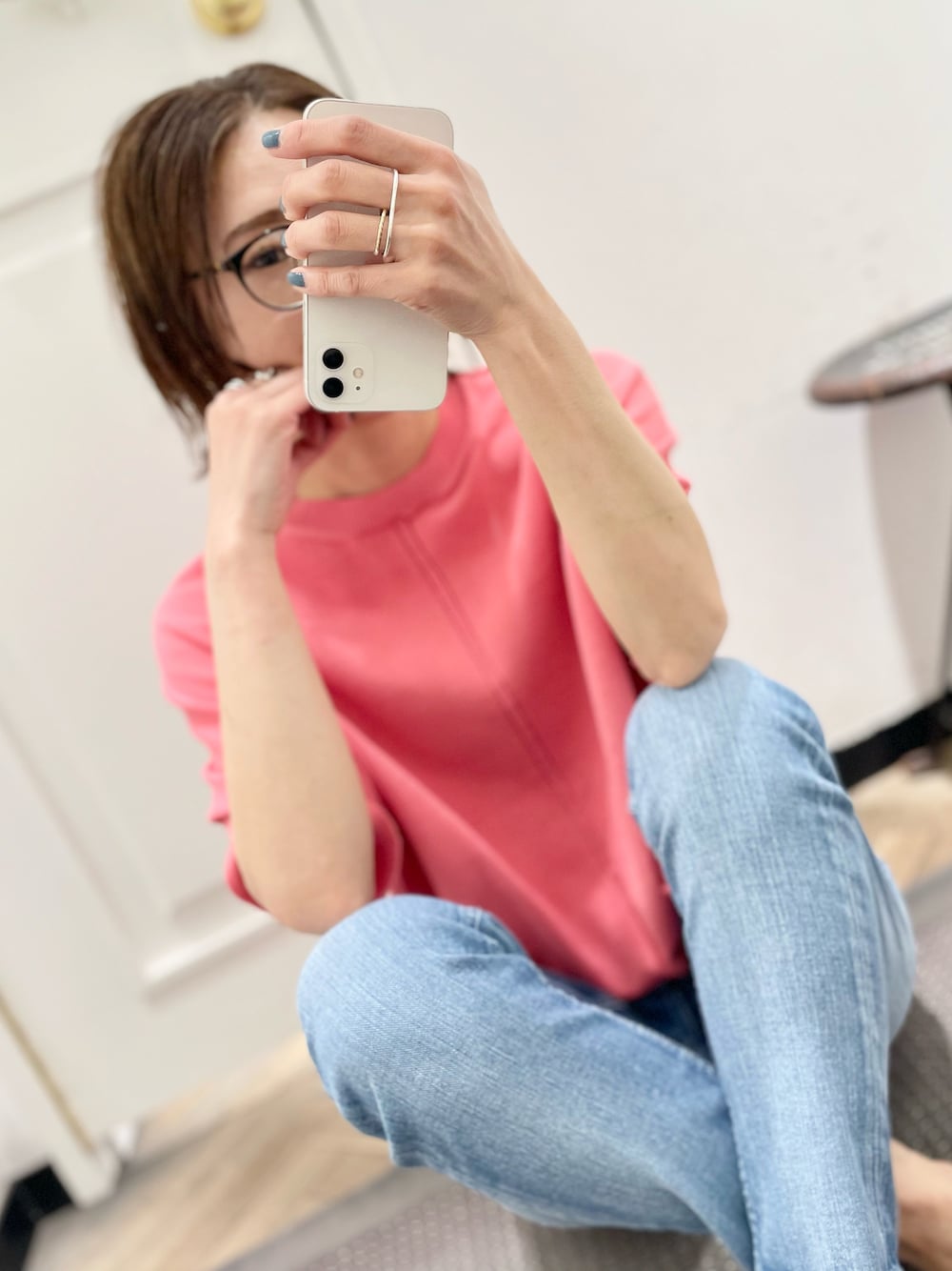 ピンク系のニット/セーター、ブルー系のデニムパンツを着用したレディースの春コーディネートの1枚目の写真