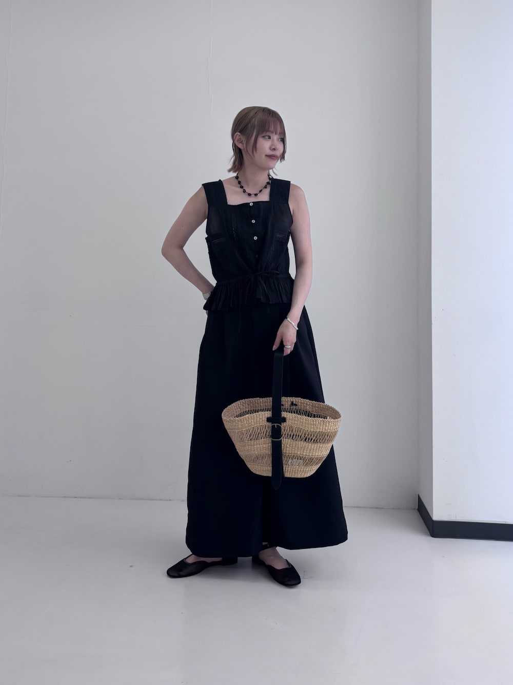 ブラック系のシャツ/ブラウス、ブラック系のその他パンツ、ベージュ系のかごバッグを着用したレディースの夏コーディネートの1枚目の写真