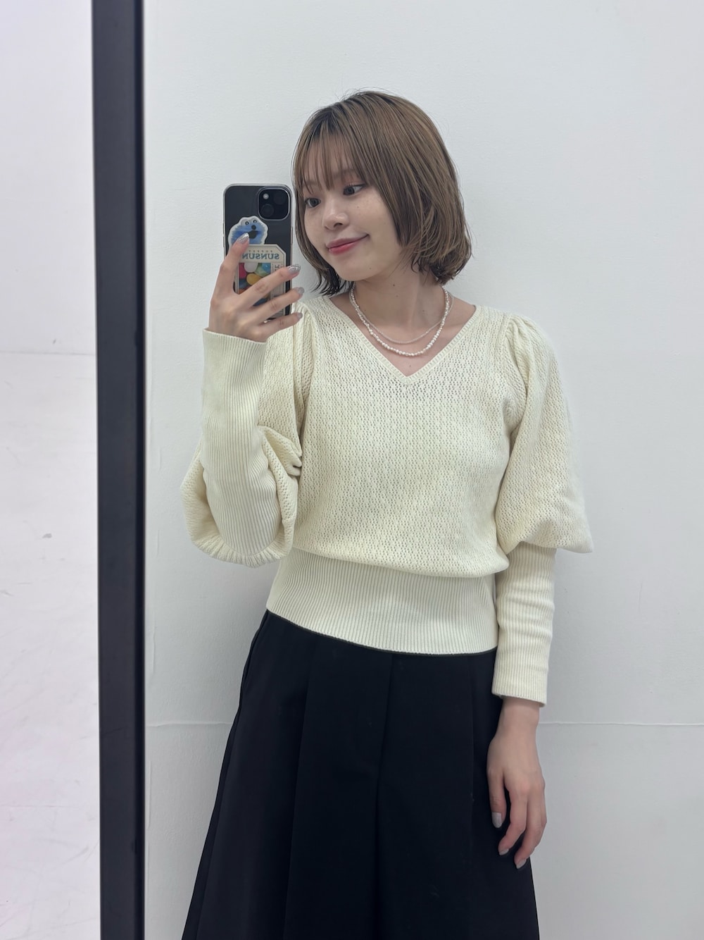 ホワイト系のニット/セーター、ブラック系のその他パンツ、ホワイト系のネックレスを着用したレディースの秋コーディネートの1枚目の写真