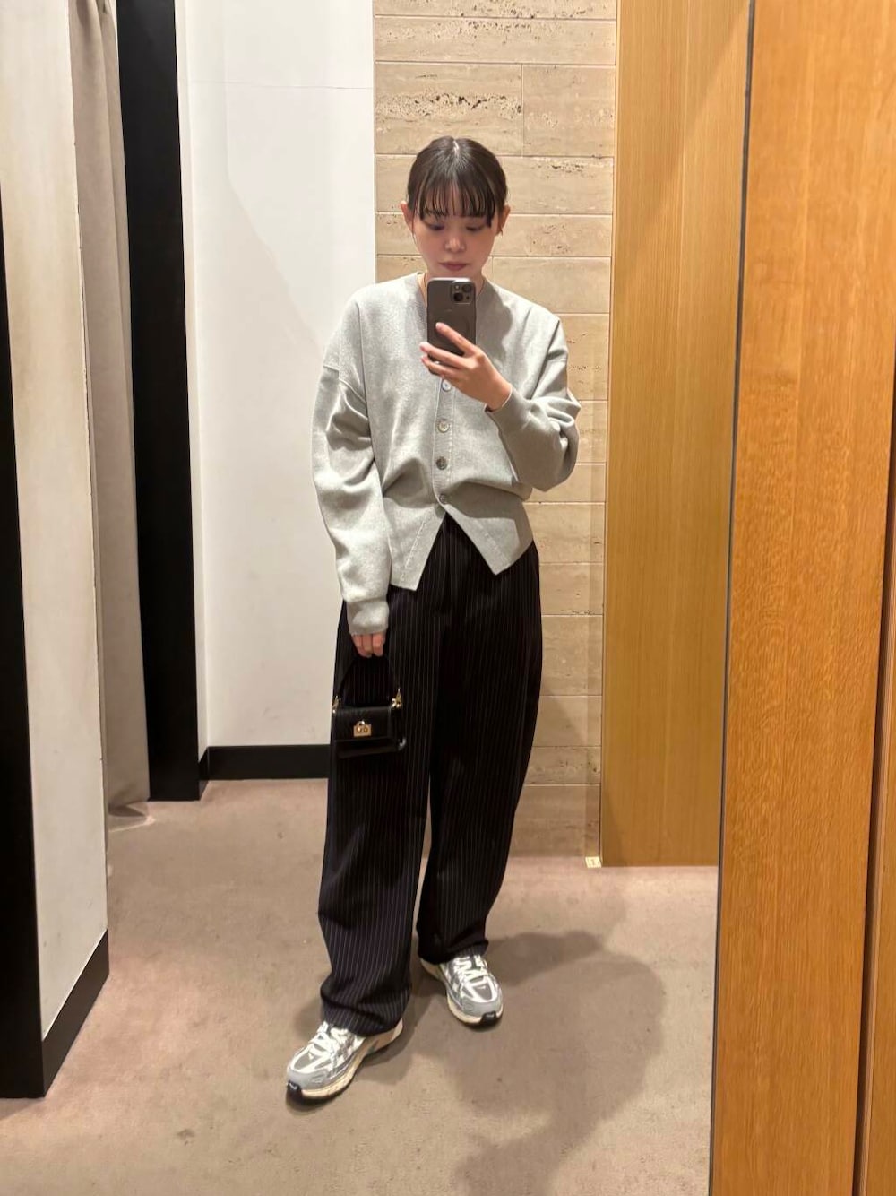 ブラック系のショルダーバッグ、ブルー系のその他パンツ、グレー系のカーディガン/ボレロを着用したレディースの冬コーディネートの1枚目の写真