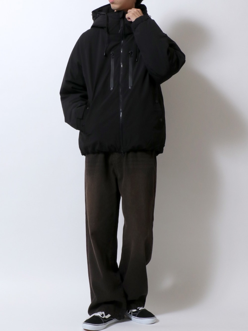 ブラック系のダウンジャケット/コート、ブラック系のデニムパンツ、ブラック系のスニーカーを着用したメンズの冬コーディネートの1枚目の写真