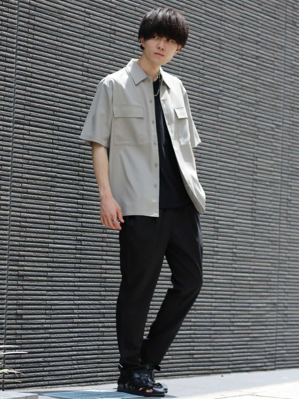 ベージュ系のセットアップ、ブラック系のTシャツ/カットソー、シルバー系のネックレスを着用したメンズの夏コーディネートの1枚目の写真