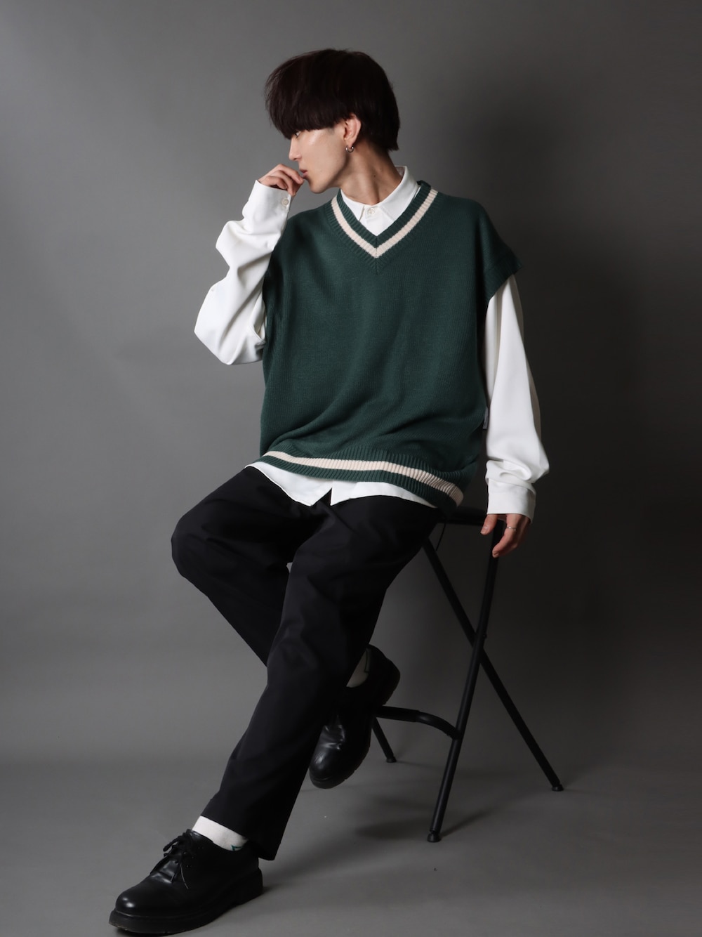 グリーン系のベスト、ホワイト系のシャツ/ブラウス、ブラック系のスラックスを着用したメンズの秋コーディネートの1枚目の写真